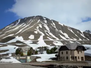 Passo del Lautaret - Dal momento che il Lautaret, case vista sulle montagne e punteggiato di neve in Parco Nazionale degli Ecrins