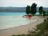 Paysages des Alpes-de-Haute-Provence - Lac de Sainte-Croix (retenue d'eau) couleur émeraude, plage de Sainte-Croix-du-Verdon, arbres et collines en arrière-plan ; dans le Parc Naturel Régional du Verdon