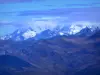 Paysages alpins de Savoie - Du col de la Madeleine, vue sur les montagnes enneigées et les nuages dans le ciel