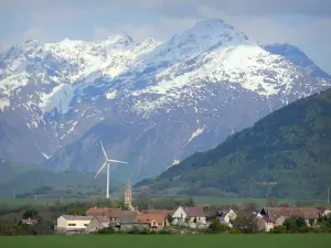 Paysages du Dauphiné - Trièves : village, éolienne, pâturages, forêt et montagnes aux cimes enneigées