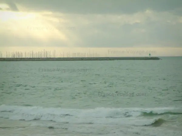 Paysages du littoral de Loire-Atlantique - Mer (océan Atlantique), mats de voiliers, phare et ciel orageux avec des rayons de soleil