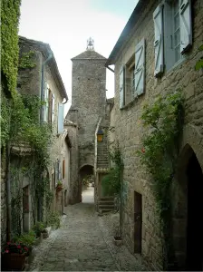 Penne - Ruelle bordée de maisons en pierre avec vue sur la porte du Pont