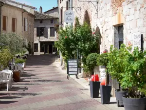 Penne-d'Agenais - Place Paul Froment square, café terrace, potted shrubs and facades of houses in the medieval town