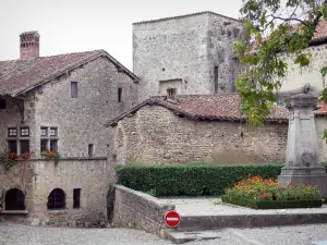 Pérouges - Ehrenmal für die Toten, Blumenbeet und Häuser des mittelalterlichen Ortes