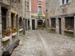 Pérouges - Narrow paved street and old houses with flower-bedecked windows