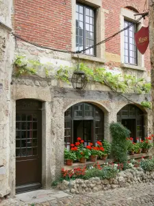 Pérouges - Façade de l'ostellerie avec ses rebords de fenêtres ornés de pots de fleurs