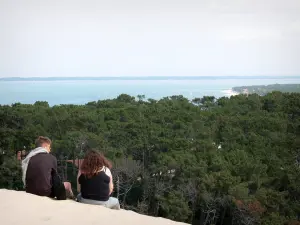 Pilat dune - Couple enjoying the view of the forest and the Arcachon basin from the Pilat dune 