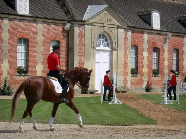 Le Pin national stud farm - Jeudis du Pin equestrian show: horse rider and facade of stable no. 1; in the town of Le Pin-au-Haras