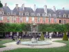 Place des Vosges - Fontaine du square Louis-XIII, rangées d'arbres et façades d'immeubles de l'ancienne place royale ; dans le quartier du Marais