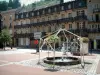 Plombières-les-Bains - Platz mit einem Springbrunnen und Wohnungen der Thermalstadt im Hintergrund