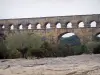 Ponte del Gard - Acquedotto romano (antico monumento) e alberi nella città di Vers-Pont-du-Gard