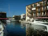 Port-Grimaud - Barcos y veleros amarrados, muelle, el puente de madera sobre el canal y las casas en la ciudad lacustre