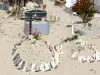 Port-Louis - Am Meer liegender Friedhof und seine Sandgräber geschmückt mit Gehäusen von Meeresmuscheln Lambis