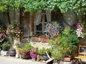 Pujols - Façade d'une maison décorée de pots de fleurs