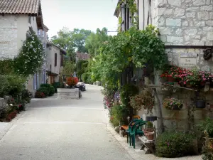 Pujols - Rue du village bordée de maisons fleuries (fleurs)