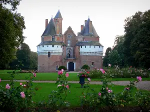 Rambures castle - Feudal fortress (fortified castle) and its wooded park (trees), lawns and rosebushes in foreground