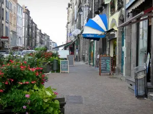 Riom - Commerce street, with its flowers, its shops and facades of houses