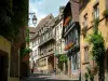 Riquewihr - Ruelle pavée en pente bordée de maisons aux façades colorées et aux fenêtres ornées de fleurs (géraniums)