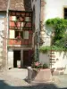 Riquewihr - Flower-bedecked well and houses decorated with flowers and creepers