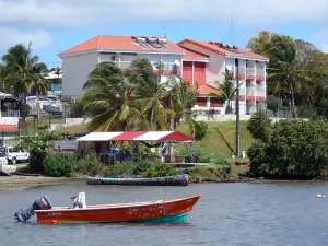 Le Robert - Building and snack at the edge of the Atlantic Ocean, with boats on the water