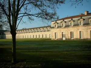Rochefort - Arbre en premier plan, pelouse parsemée de feuilles mortes et Corderie royale (édifice abritant le Centre International de la Mer)