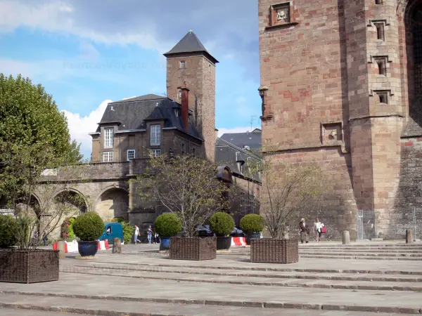 Rodez - Place d'Armes decorado con plantas, Catedral de Notre Dame en piedra arenisca de color rosa y el Palacio Episcopal