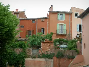 Roussillon - Häuser mit ockerfarbenen Fassaden und Bäume des Dorfes