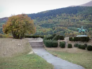 Route Napoléon - Prairie van de vergadering met het ruiterstandbeeld van Napoleon I, bomen met herfstkleuren op de achtergrond, de stad van Laffrey