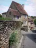 Saint-Benoît-du-Sault - Sloping street and houses of the village, stone wall in foreground