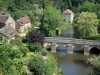 Saint-Céneri-le-Gérei - Flussbrücke überspannend den Fluss Sarthe, Häuser des Dorfes und Bäume am Flussrand; in den Alpen Mancelles, im Regionalen Naturpark Normandie-Maine