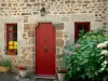 Saint-Céneri-le-Gérei - Casa de piedra, con puerta y ventanas de rojo, macetas y Hortensia