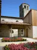 Saint-Clar - Blühende Blumenbeete des Gartens der vier Jahrenzeiten und Glockenturm der alten Kirche
