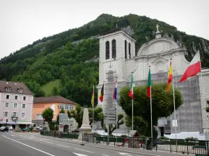 Saint-Claude - Basilica di San Pietro, bandiere, strada, edifici e alberi nel Parco Naturale Regionale di Haut-Jura