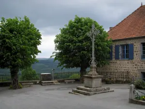 Saint-Georges-Nigremont - Maison en pierre du village, arbres, point de vue (table d'orientation) sur les environs et ciel orageux