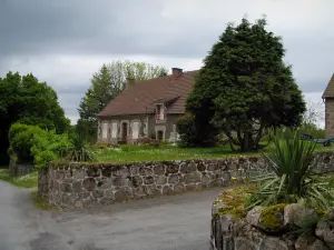 Saint-Georges-Nigremont - Maison du village, arbres et ciel orageux