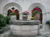 Saint-Gilbert abbey - Flower-bedecked well and bays of the chapter house of the Saint-Gilbert Neuffonts abbey; in the town of Saint-Didier-la-Forêt