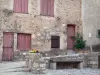 Saint-Guilhem-le-Désert - Façade d'une maison, banc et fleurs en pot