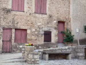 Saint-Guilhem-le-Désert - Facade of a house, bench and flowers in jar