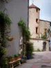 Saint-Haon-le-Châtel - Fachada decorada con flores y vides, y la casa del reloj de sol en el fondo