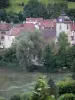 Saint-Hippolyte - Kerktoren, daken van huizen en bomen in de stad aan het water (rivier)