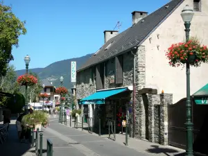 Saint-Lary-Soulan - Thermalbad (Kurort) und Wintersportort: Dorfstrasse gesäumt von Häusern und Strassenlaternen geschmückt mit Blumen; im Tal Aure