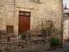 Saint-Martin-de-Londres - Maison en pierre, rosier grimpant (roses) ornant la façade, rambarde en fer forgé, plantes en pots