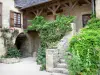 Saint-Robert - Demeure en pierre, ornée de plantes en fleurs, donnant sur la Vieille Rue