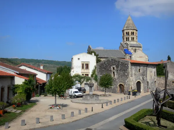 Saint-Saturnin - Dos pisos de la torre octogonal de la iglesia románica Saint-Saturnin, fuente y casas de la aldea medieval en el Parque Natural Regional de los Volcanes de Auvernia