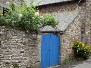 Saint-Suliac - Blaues Türchen, Mauer der Einzäumung aus Stein, Rosenstöcke (Rosen)
und Blumen