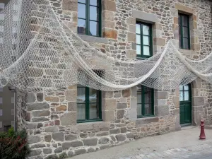 Saint-Suliac - Facade of a stone house decorated with a fishing net