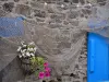 Saint-Suliac - Facciata in pietra decorata con una rete da pesca e un vaso di fiori