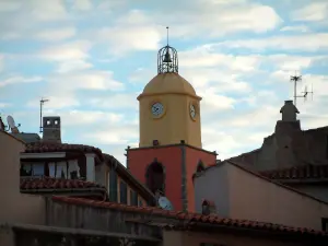 Saint-Tropez - Kirchturm der Kirche mit lebendigen Farben, Häuser der Altstadt und Wolken im blauen Himmel