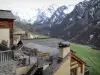 Saint-Véran - Toits de maisons du village montagnard recouverts de bardeaux de mélèze avec vue sur le torrent et les montagnes aux cimes enneigées ; dans le Parc Naturel Régional du Queyras