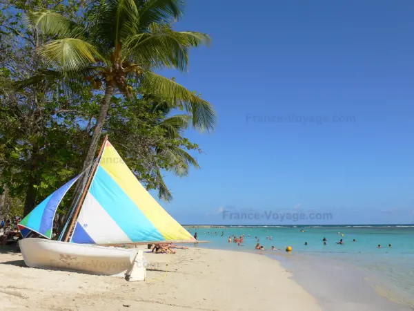 Sainte-Anne - Plage du Bourg de Sainte-Anne en la isla de Grande - Terre, con su laguna, cocoteros y un pequeño barco en la arena